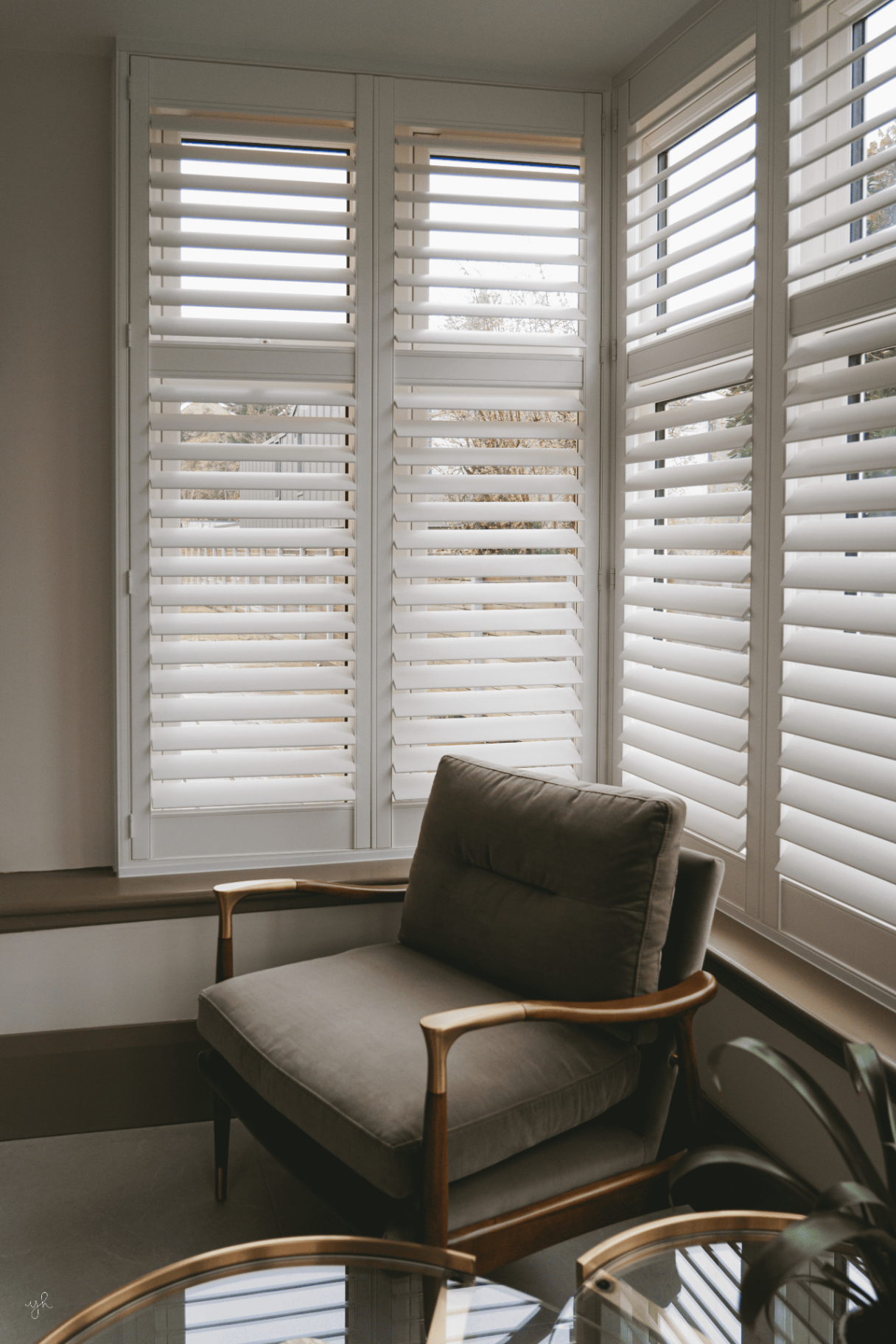 White full height shutters in a bright corner seating area